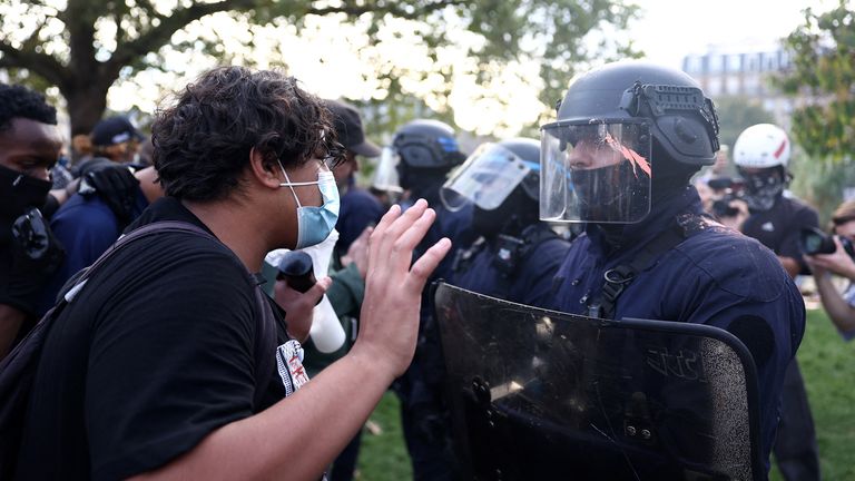 A masked protester faces off with French CRS riot police at the Place de la Nation in Paris during school demonstrations. Pic: Reuters