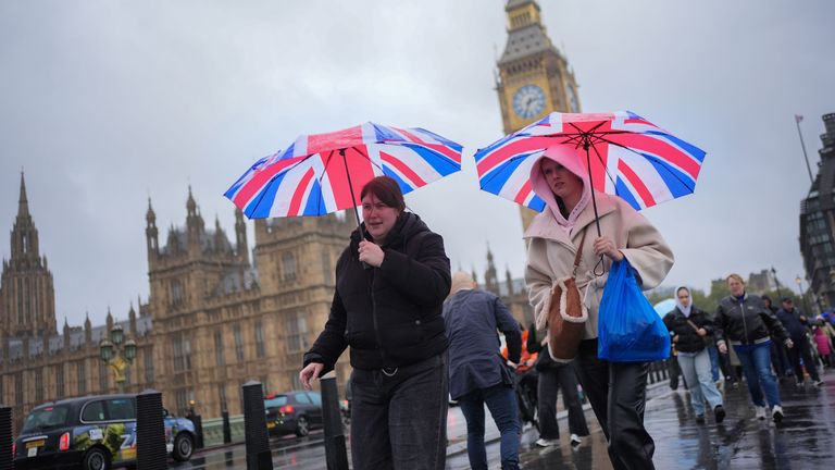 People walking in the rain on Westminster Bridge in London during Storm Austen.
Pic: PA