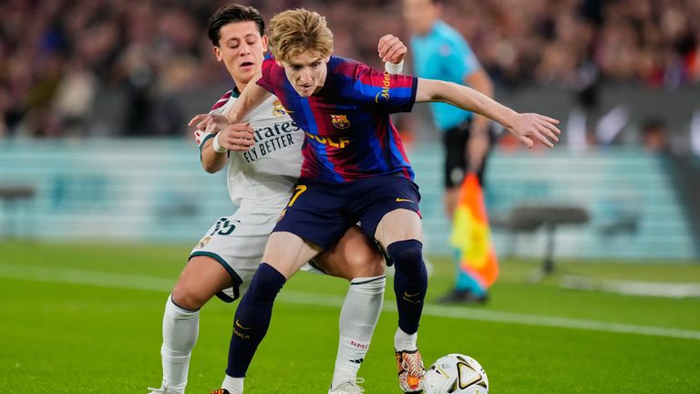 Barcelona's Anthony Gordon, right, is challenged by Real Madrid's Arda Guler