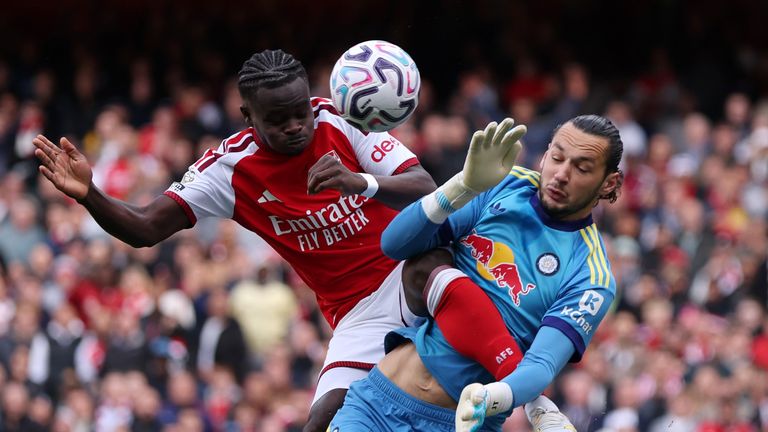 Bukayo Saka of Arsenal jumps for the ball with James Trafford of Leeds United