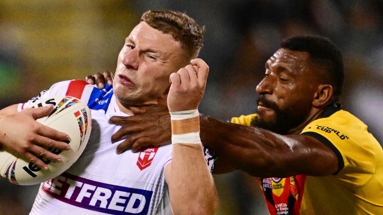 England's George Williams is tackled by Nixon Putt of Papua New Guinea during the Rugby League World Cup (Associated Press)