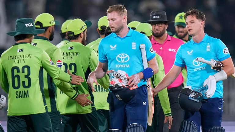 England's Gus Atkinson, fourth right, and Sonny Baker, right, shakes hand with Pakistani players