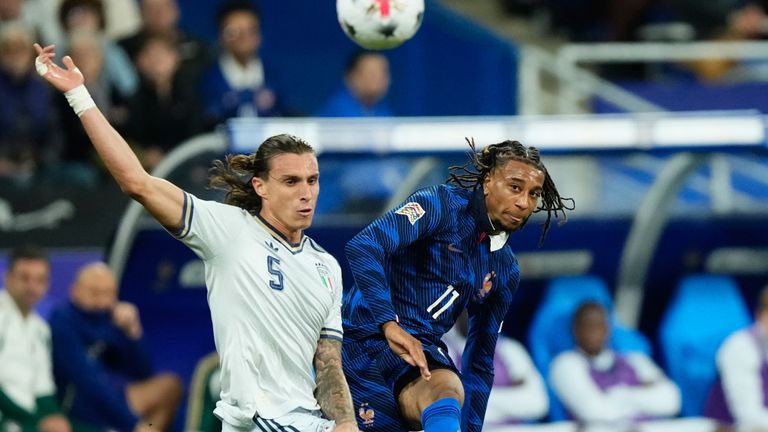 Italy's Riccardo Calafiori, left, and France's Michael Olise challenge for the ball