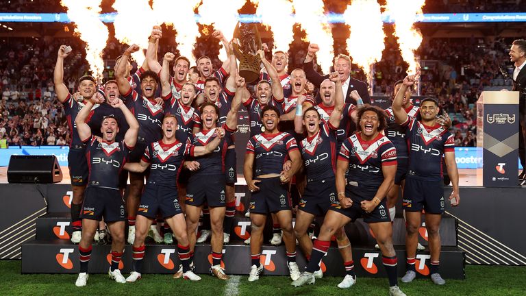 SYDNEY, AUSTRALIA - OCTOBER 04: James Tedesco of the Roosters holds aloft the Provan-Summons Trophy as the team celebrates after winning the