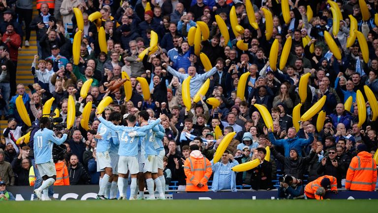 Manchester City players celebrate in front of a sea of inflatable bananas 