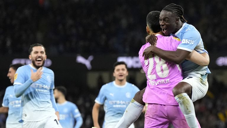 Manchester City goalkeeper Geronimo Rulli and Jeremy Doku embrace as they celebrate the penalty shoot-out win over Brighton