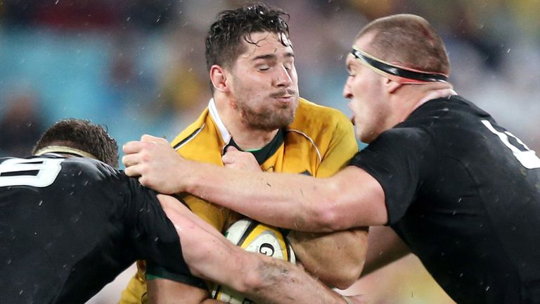 FILE - Australia's Nathan Charles, center, charges through the defense of New Zealand's Kieran Read, left, and Brodie Retallic during their Bledisloe Cup rugby union test match in Sydney, Saturday, Aug. 16, 2014. (AP Photo/Rick Rycroft, File)