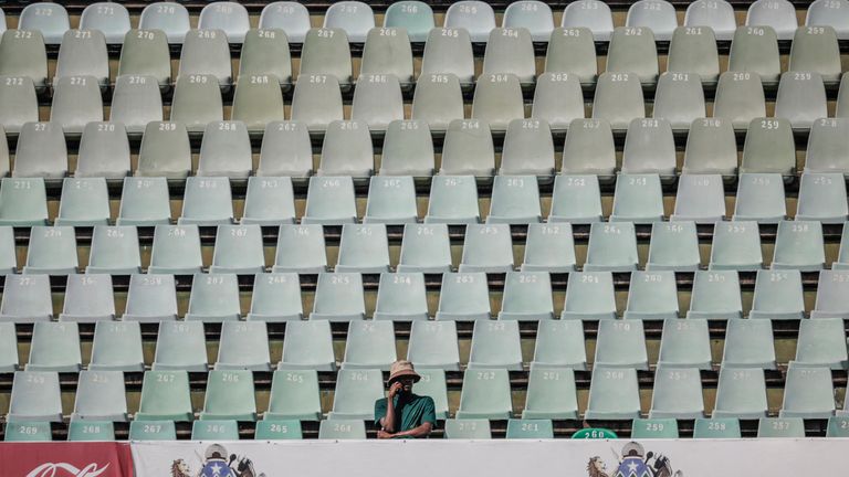 A cricket supporter sits alone in the stands to watch on day four of the first Test match between South Africa and Australia at the Kingsmead stadium in Durban on October 12, 2026. (Photo by Marco Longari / AFP)